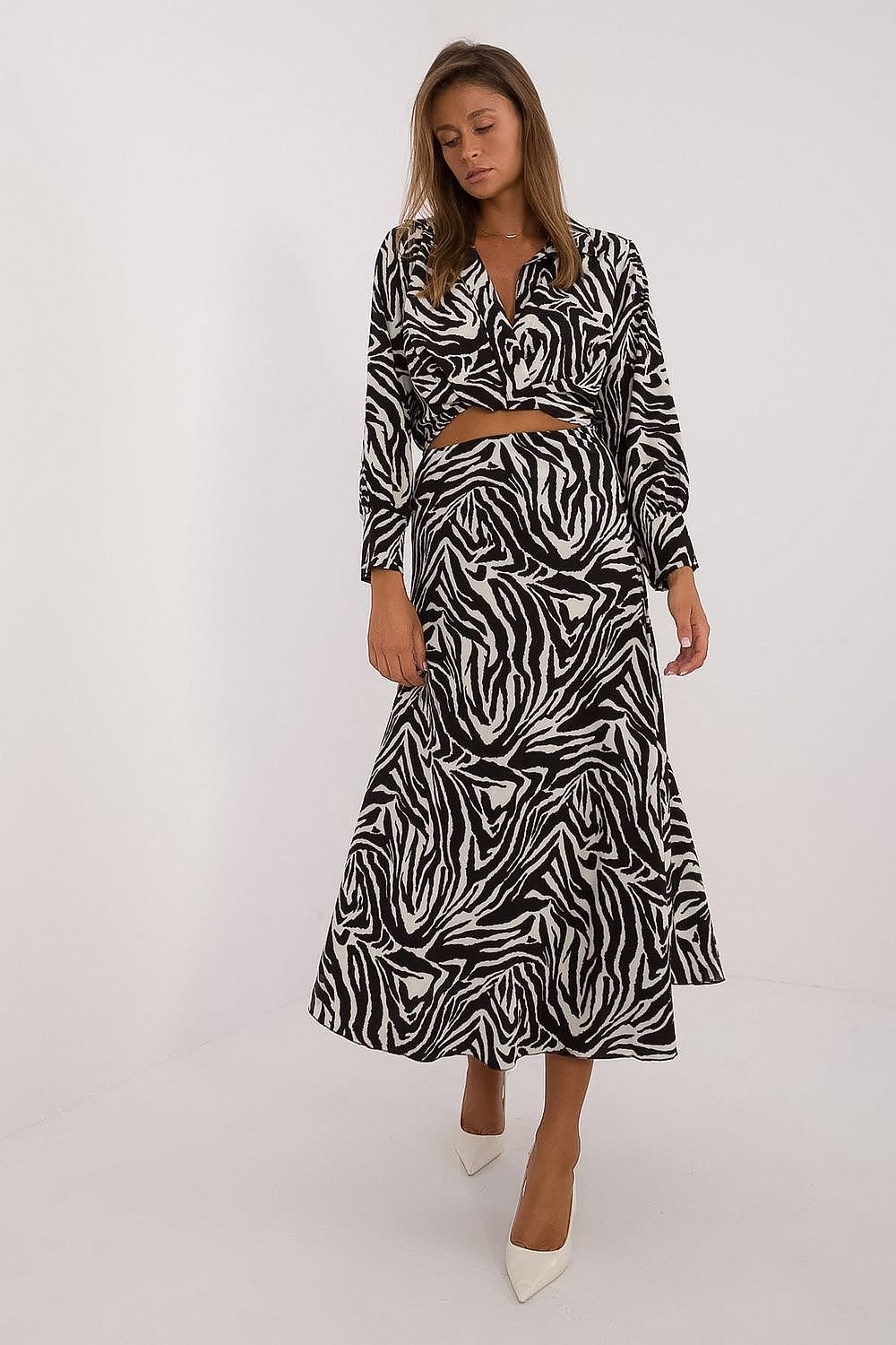 Een vrouw draagt een elegante, zwart-witte jurk met een opvallend zebrapatroon en een wikkelmodel bovenstuk met lange mouwen.voorzijde uitzicht.