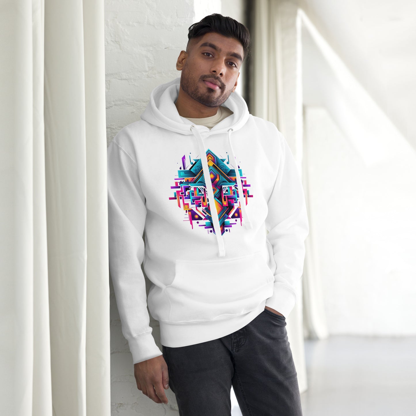 Een wit unisex premium hoodie met een geometrische afbeelding, gedragen door een man, vooraanzicht, met een gordijn als achtergrond