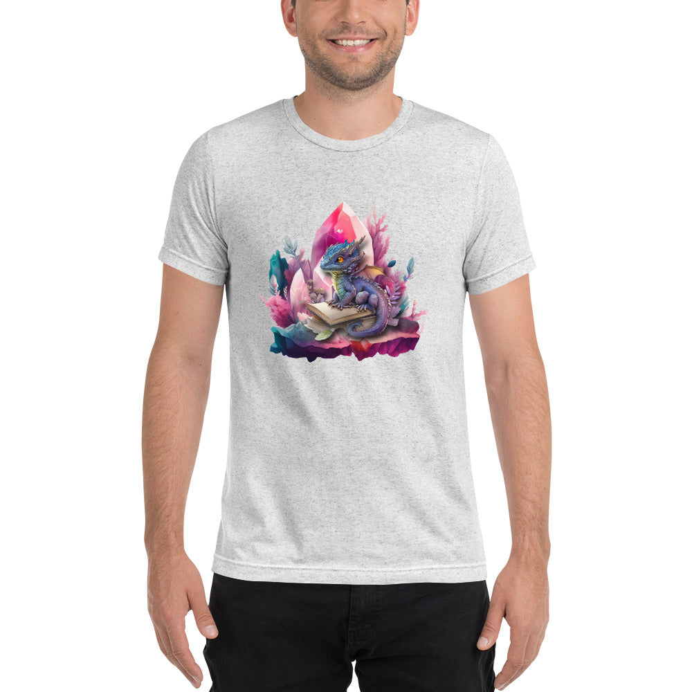 Een wit gevlekt triblend unisex T-shirt met een afbeelding van een kleine draak en een magisch boek, gedragen door een blije man, op een witte achtergrond. De man staat naar voren gericht.