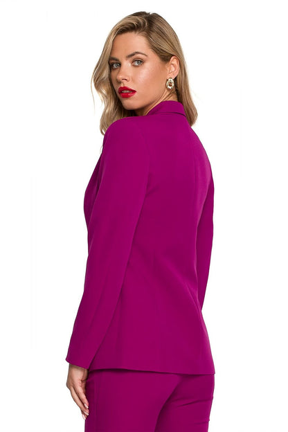 Vrouw draagt een fuchsia getailleerde blazer met goudkleurige knoop.zij uitzicht