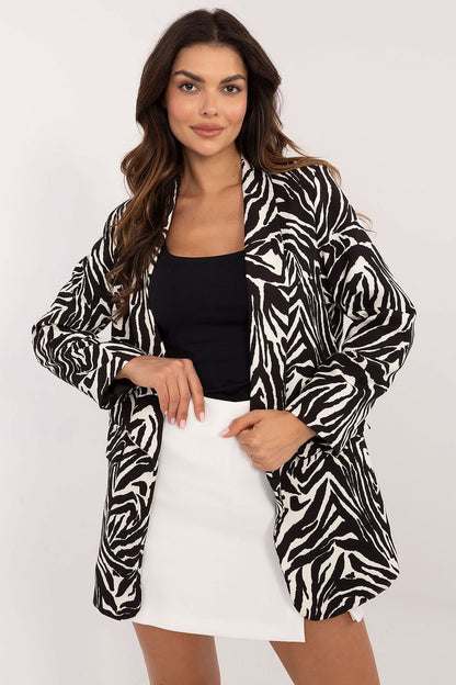 Een blije vrouw draagt een elegant gevoerd damesjack met luxe dierenprint,  met een zwarte blouse en witte mini rok voor aanzicht, pose