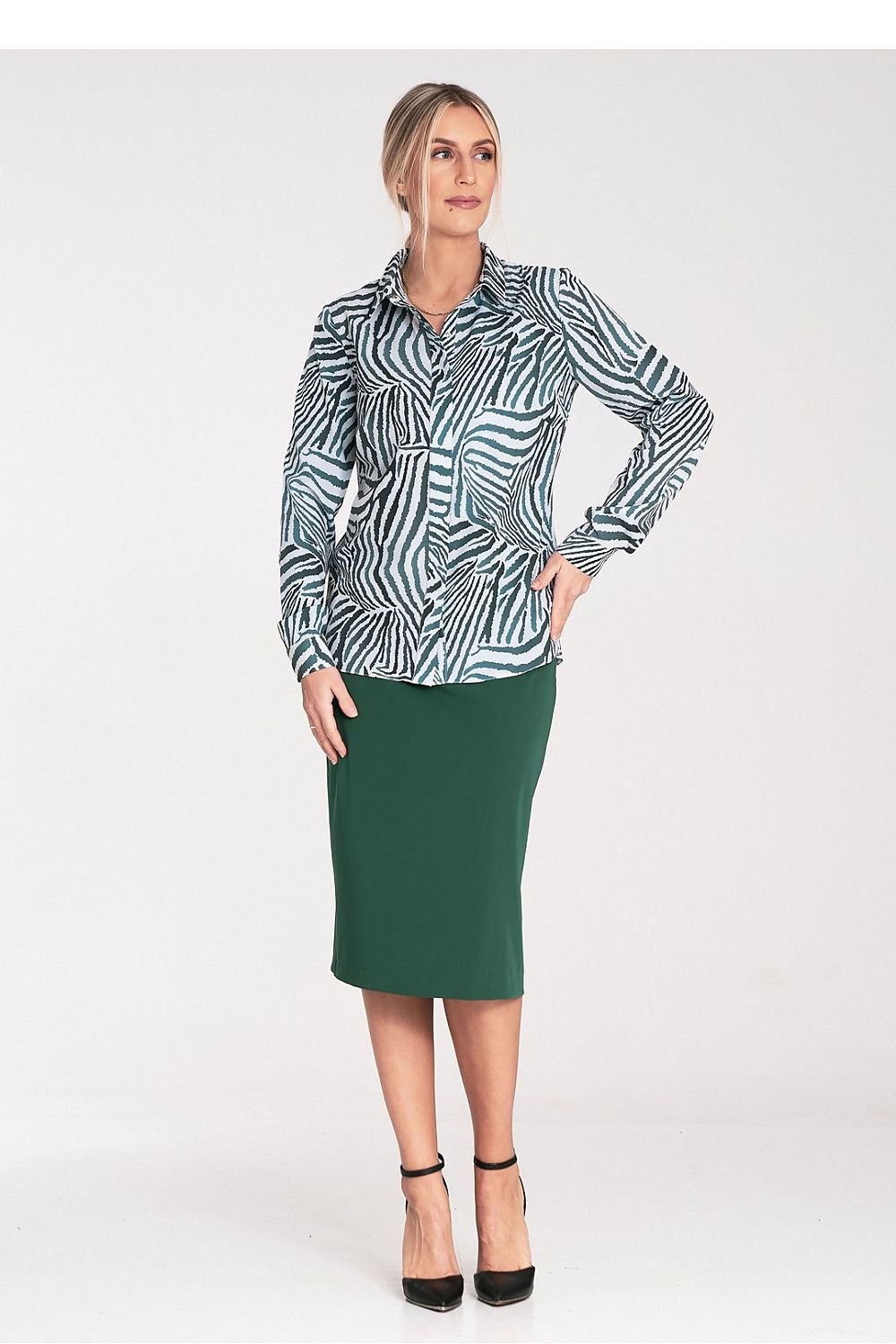 Vrouw draagt een elegant klassiek damesshirt met kraag, verborgen sluiting en zilverkleurige knopen op kraag en manchetten,voor aan zicht, rechts kijkend