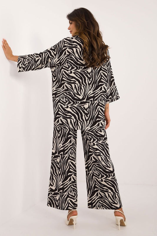 Modieuze dames set met shirt en wijde broek, voorzien van dierenprint en comfortabele pasvorm. achter aanzicht,beige achter grond
