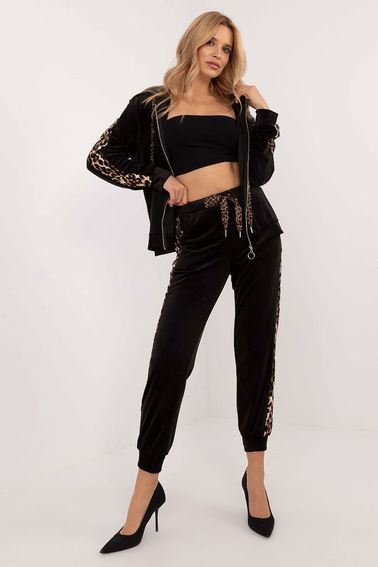 Vrouw draagt een velours damesset met sweatshirt en broek, comfortabel en stijlvol met dierenprintdetails, perfect voor alledaags gebruik,voor aanzicht